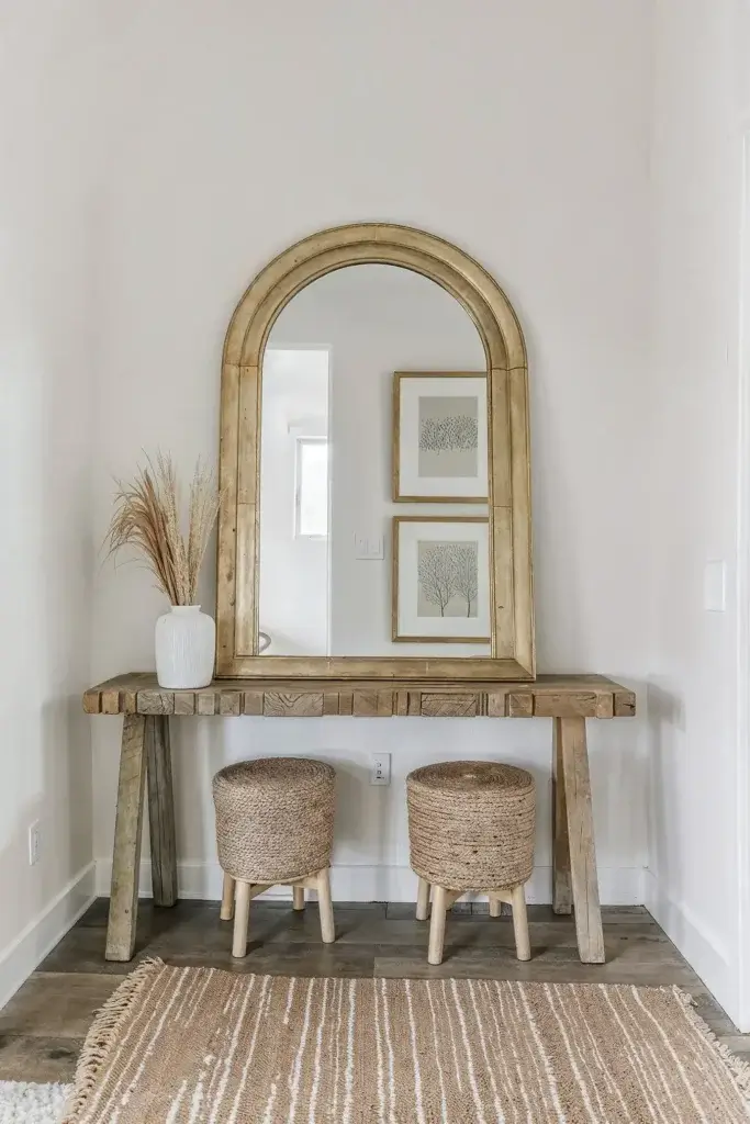 Home Elfin view 5 interior design inspiration. minimalist yet elegant interior shot showcases a thoughtfully styled vignette centered around a striking gold-framed arched mirror.